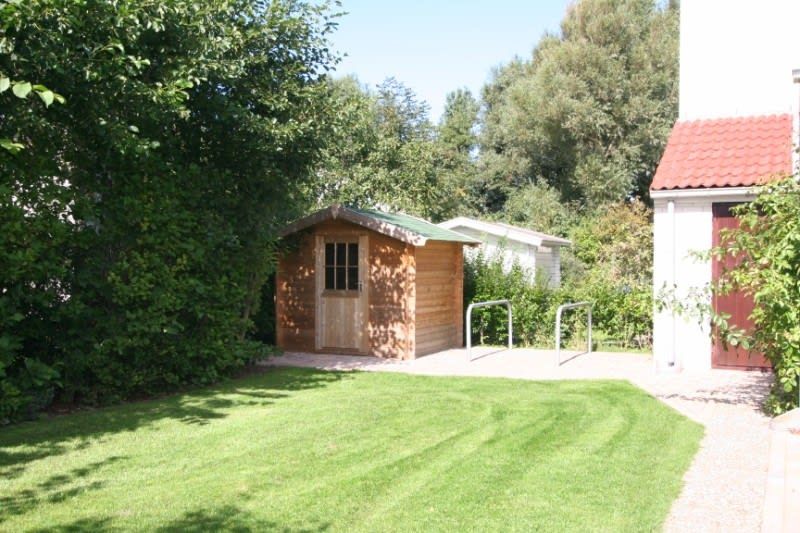 Vakantiehuis D 662 in De Cocksdorp, Texel met groene tuin en houten schuurtje, ideaal voor natuurliefhebbers op de Waddeneilanden.