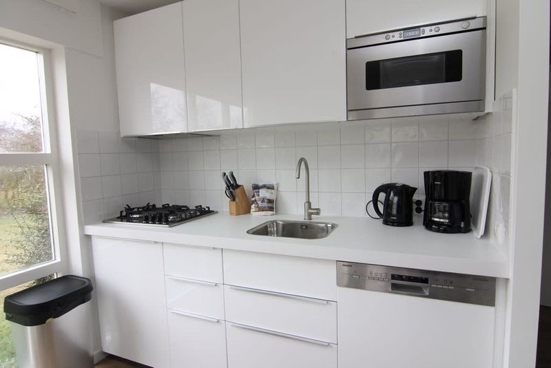 Moderne keuken in Vakantiehuis D 800, De Cocksdorp, Texel. Voorzien van apparatuur en strakke witte kasten voor een comfortabel verblijf.