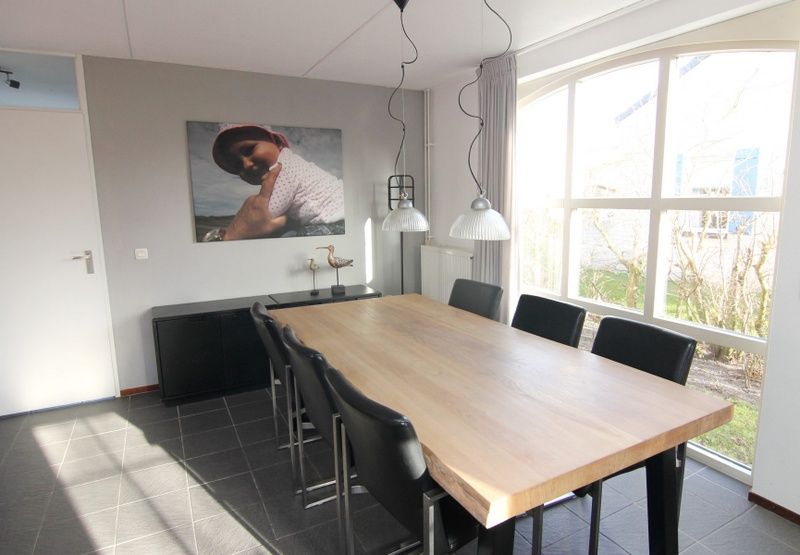 Gezellige eetkamer in Vakantiehuis E 724, De Cocksdorp, Texel met ruime tafel en veel natuurlijk licht, ideaal voor een ontspannen verblijf.