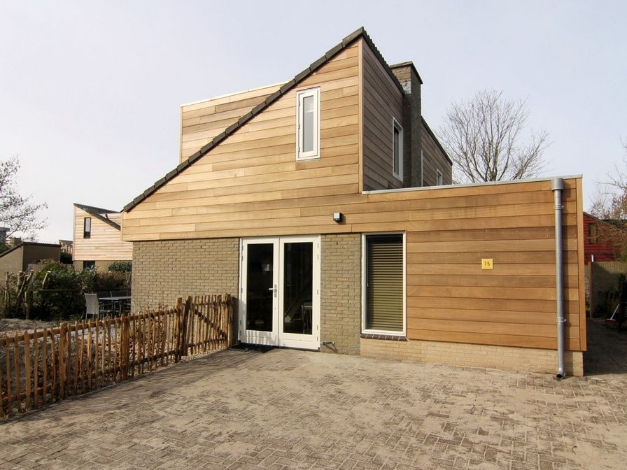 Vacation home A 075 in De Cocksdorp, Texel: modern vacation home with wooden facade and spacious outdoor area on the Wadden Islands.