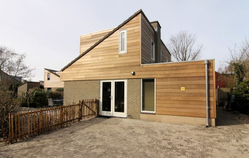 Vacation home A 075 in De Cocksdorp, Texel, Wadden Islands offers a modern exterior with spacious veranda for a relaxing stay.