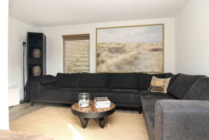 Cozy living room of Holiday home A 075 in De Cocksdorp, Texel, with comfortable seating area and nature decor for a relaxing stay.