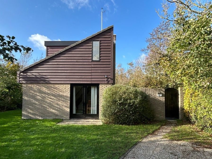 Vakantiehuis A 051 in De Cocksdorp, Texel, omgeven door groene natuur en een zonnige tuin, perfect voor een ontspannen verblijf op de Waddeneilanden.