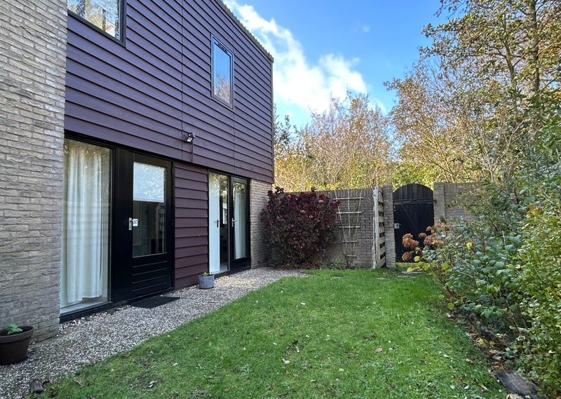 Vakantiehuis A 051 in De Cocksdorp, Texel biedt een serene tuinomgeving met een uitnodigende buitenruimte voor ontspanning op de Waddeneilanden.