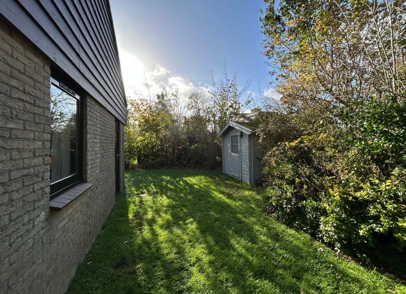 Rustige tuin bij Vakantiehuis A 051 in De Cocksdorp, Texel. Geniet van de groene omgeving en privacy van dit charmante vakantieverblijf.