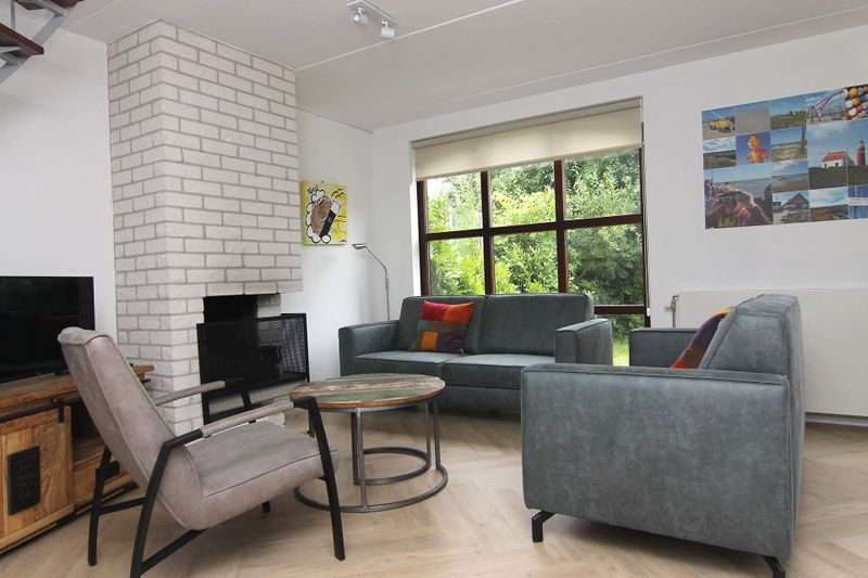 Gezellige woonkamer van Vakantiehuis D 475 in De Cocksdorp, Texel, met moderne meubels en uitzicht op de groene natuur van de Waddeneilanden.