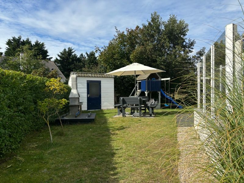 Ontspan in de tuin van Vakantiehuis F 471 in De Cocksdorp, Texel. Geniet van het terras en de speeltuin in de rustige omgeving van de Waddeneilanden.