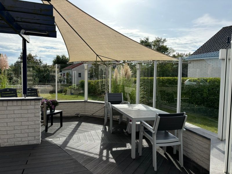 Geniet van de zonnige veranda bij Vakantiehuis F 471 in De Cocksdorp, Texel. Ontspan op het terras met uitzicht op de groene omgeving.
