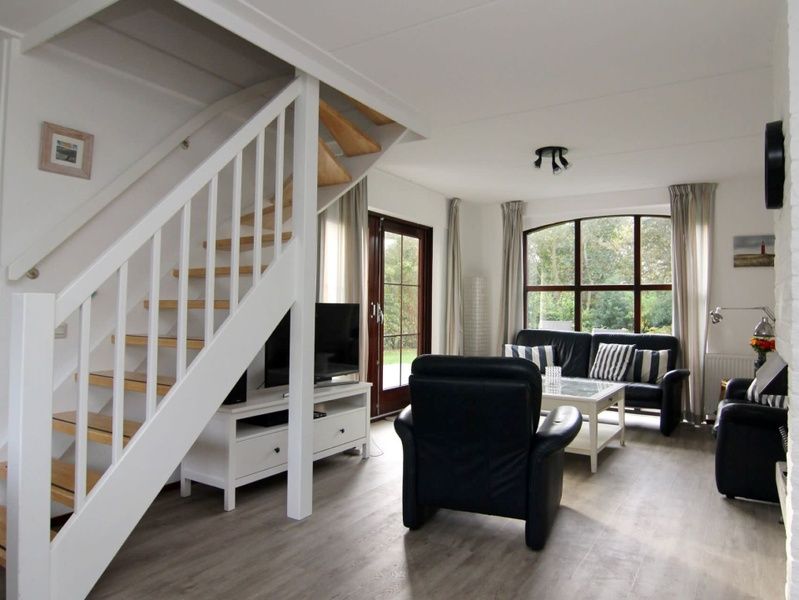 Gezellige woonkamer van Vakantiehuis F 575 in De Cocksdorp, Texel, met comfortabele zitruimte en uitzicht op de natuur van de Waddeneilanden.