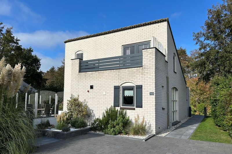 Vakantiehuis F 742 in De Cocksdorp, Texel, biedt een charmante buitenkant met moderne architectuur en een uitnodigend terras.
