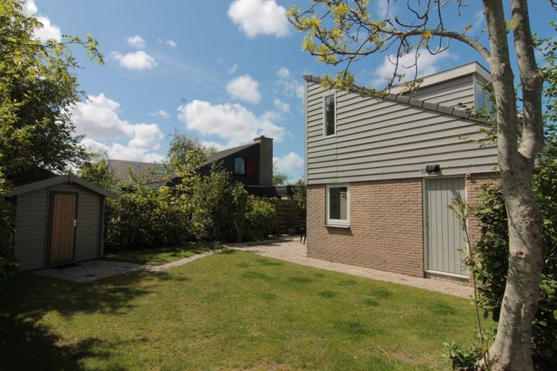Vakantiehuis G 263 in De Cocksdorp, Texel, biedt een serene tuin en moderne architectuur, ideaal voor een ontspannen verblijf op de Waddeneilanden.