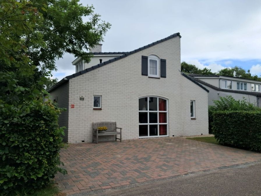 Vakantiehuis E 539 in De Cocksdorp, Texel, biedt een charmante buitenkant met een uitnodigend terras en groene omgeving op de Waddeneilanden.