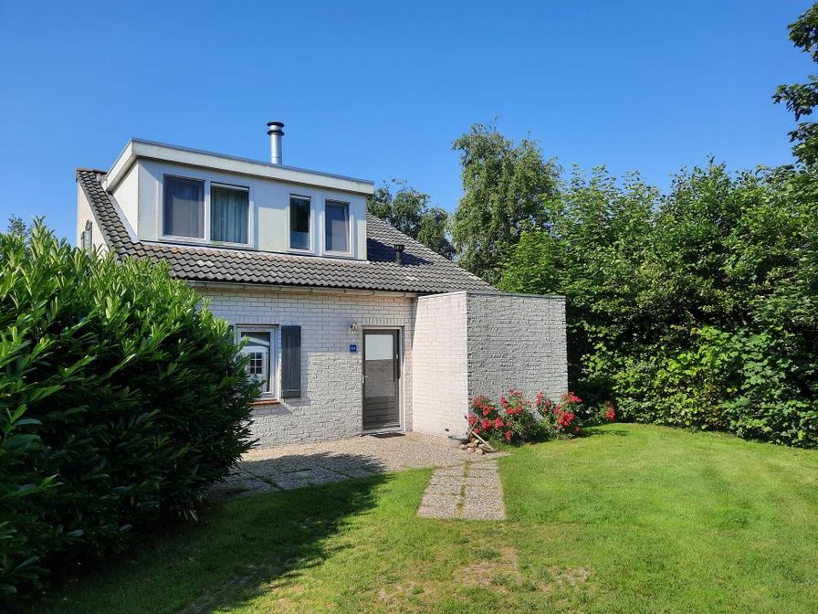 Vakantiehuis F 654 in De Cocksdorp, Texel, Waddeneilanden, omgeven door groene natuur en een zonnig terras voor een ontspannen verblijf.