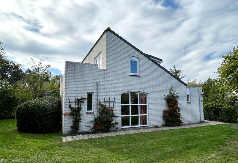 Vakantiehuis F 647 in De Cocksdorp, Texel, biedt een serene buitenkant met groene tuin en weelderige natuur, ideaal voor ontspanning op de Waddeneilanden.