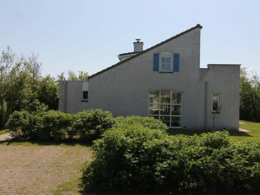 Vakantiehuis F 691 in De Cocksdorp, Texel, biedt een serene omgeving met een charmante buitenkant en groene tuin op de Waddeneilanden.