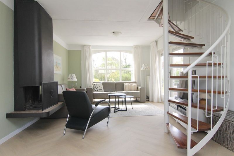 Lichte woonkamer van Vakantiehuis F 691 in De Cocksdorp, Texel, met moderne inrichting en uitzicht op de groene omgeving.