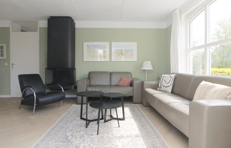 Stijlvolle woonkamer in Vakantiehuis F 691, De Cocksdorp, Texel met comfortabele banken en moderne inrichting, ideaal voor ontspanning.
