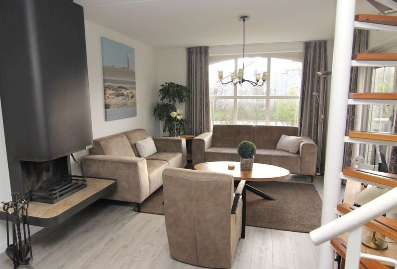 Gezellige woonkamer van Vakantiehuis F 604 in De Cocksdorp, Texel met comfortabele zitruimte en uitzicht op de groene omgeving.