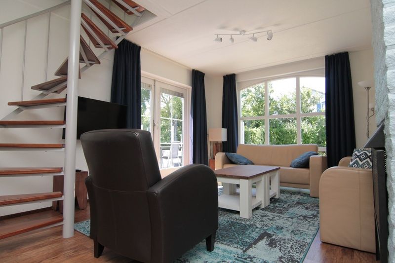 Gezellige woonkamer van Vakantiehuis F 686 in De Cocksdorp, Texel, met comfortabele zithoek en uitzicht op de groene omgeving.