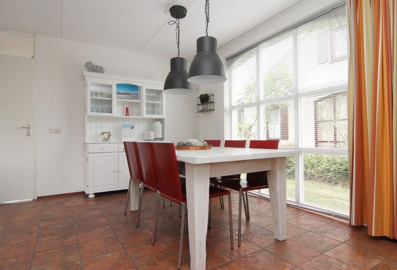 Gezellige eetkamer van Vakantiehuis E 646 in De Cocksdorp, Texel. Ruime binnenruimte met veel lichtinval en moderne inrichting.