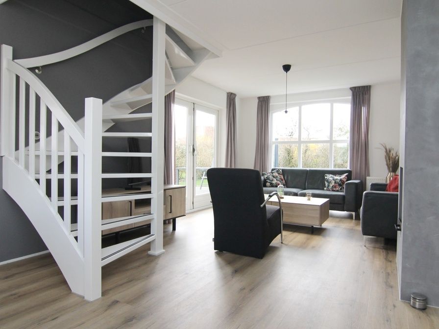 Gezellige woonkamer in Vakantiehuis E 507, De Cocksdorp, Texel, met moderne inrichting en uitzicht op de groene omgeving van de Waddeneilanden.