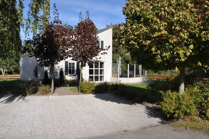 Das Ferienhaus F 778 in De Cocksdorp, Texel, bietet einen ruhigen Aussenbereich mit gruener Umgebung und einer grossen Terrasse zum Entspannen auf den Watteninseln.