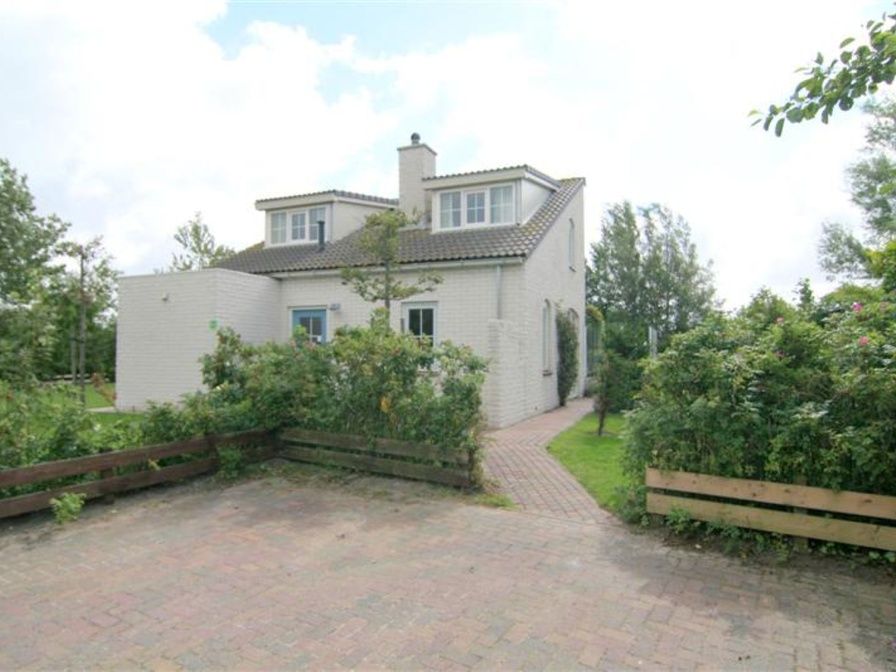 Vacation home F 681 in De Cocksdorp, Texel, surrounded by green nature and an inviting path to the front door.