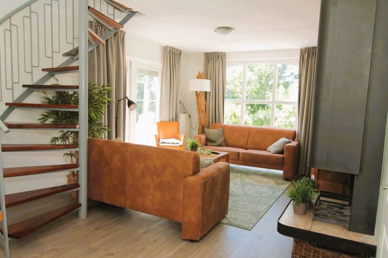 Cozy living room of Holiday home F 681 in De Cocksdorp, Texel with comfortable seating area and large windows for a beautiful view.