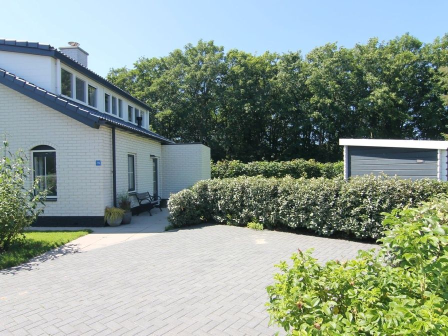Vacation home F 776 in De Cocksdorp, Texel offers a serene outdoor space with green surroundings and spacious driveway, ideal for a relaxing stay.
