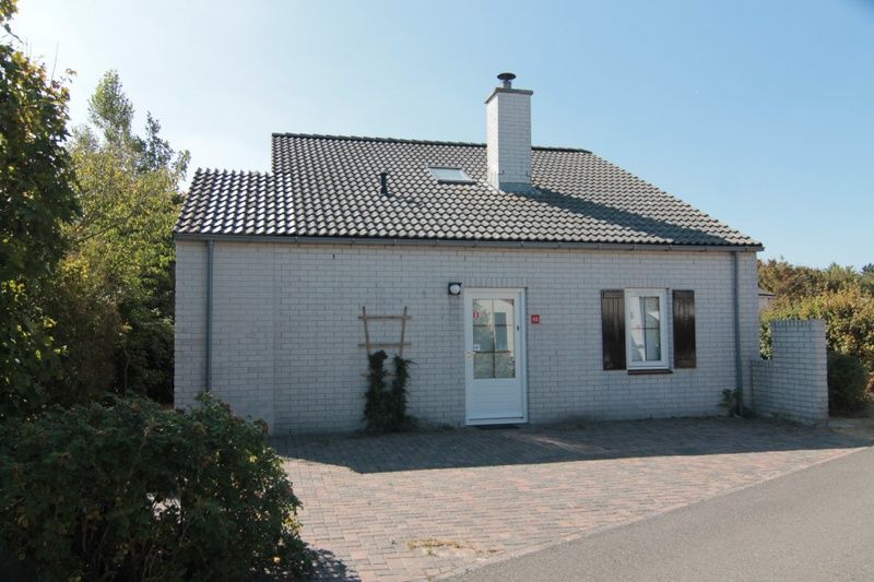 Vakantiehuis E 413 in De Cocksdorp, Texel, biedt een charmante buitenkant met een zonnig terras op de Waddeneilanden.