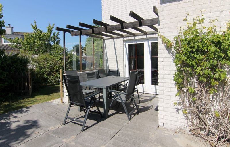 Zonnig terras met moderne meubels bij Vakantiehuis E 413 in De Cocksdorp, Texel, ideaal vakantiehuis op de Waddeneilanden.