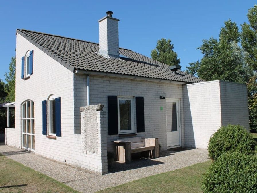Das Ferienhaus F 713 in De Cocksdorp, Texel, bietet eine charmante Unterkunft mit einem gemuetlichen Aussenbereich und der umliegenden Natur.