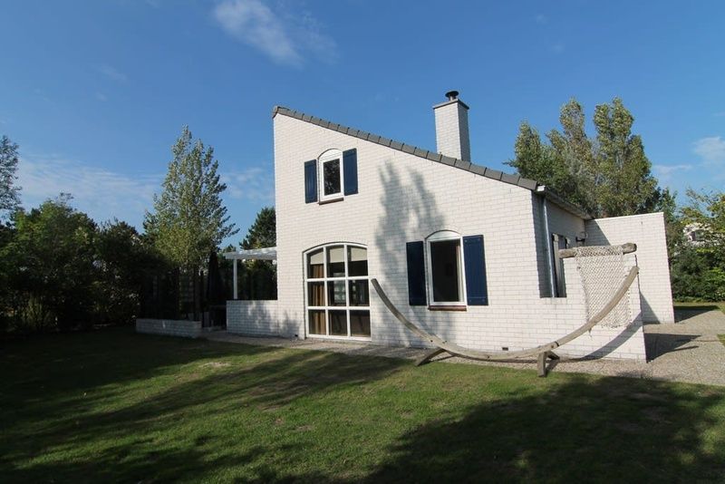 Das Ferienhaus F 713 in De Cocksdorp, Texel, bietet einen ruhigen Aussenbereich mit gruener Umgebung und einladender Architektur.