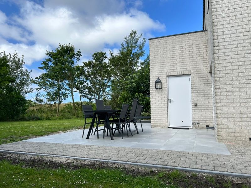 Geniet van het terras bij Vakantiehuis F 765 in De Cocksdorp, Texel, omgeven door groene natuur en rust van de Waddeneilanden.