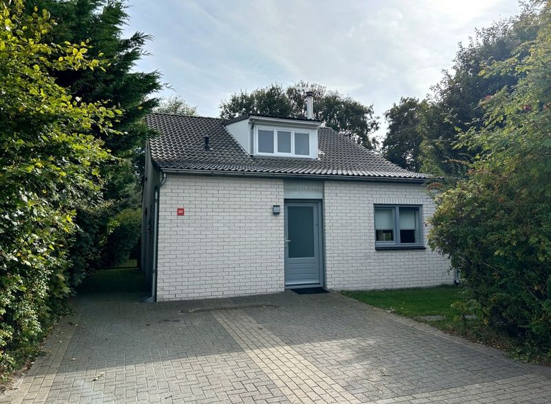 Vakantiehuis E 397 in De Cocksdorp, Texel, biedt een charmante buitenaanblik met groene omgeving voor een ontspannen eilandverblijf.
