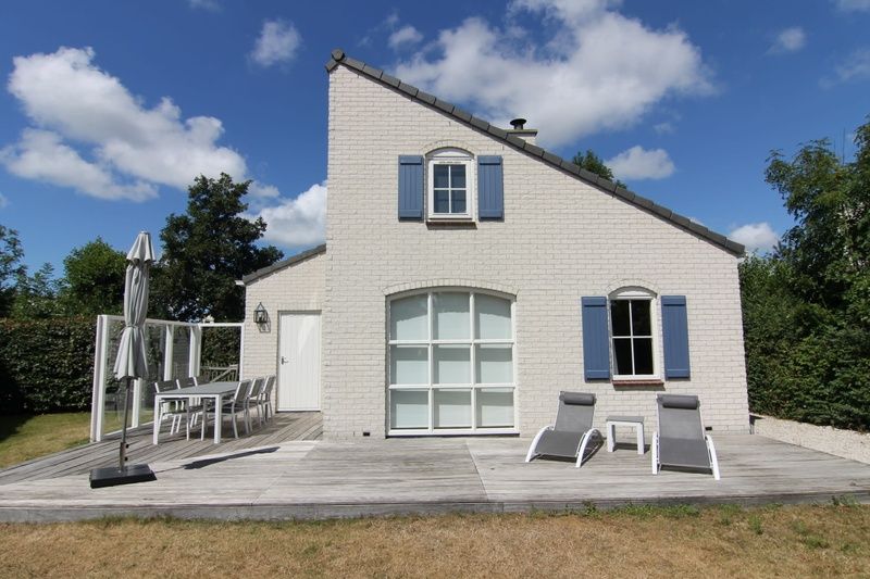 Vakantiehuis E 634 in De Cocksdorp, Texel biedt een zonnig terras met comfortabele ligstoelen en een schilderachtig uitzicht op de natuur.