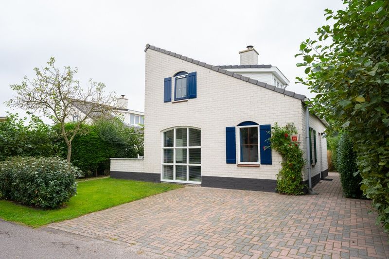 Vacation home E 541 in De Cocksdorp, Texel offers a charming exterior with a green garden and ample parking in the Wadden Islands.