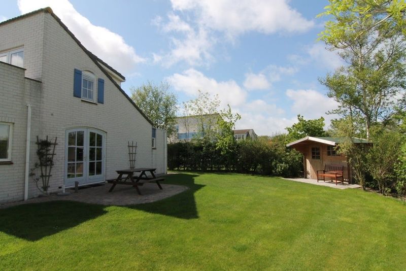 Vakantiehuis F 602 in De Cocksdorp, Texel, biedt een ruime tuin met terras en groene omgeving voor een ontspannen verblijf op de Waddeneilanden.