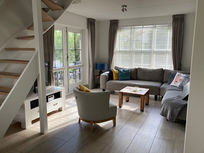 Gezellige woonkamer van Vakantiehuis E 501 in De Cocksdorp, Texel. Comfortabele zithoek met veel lichtinval en uitzicht op het terras.