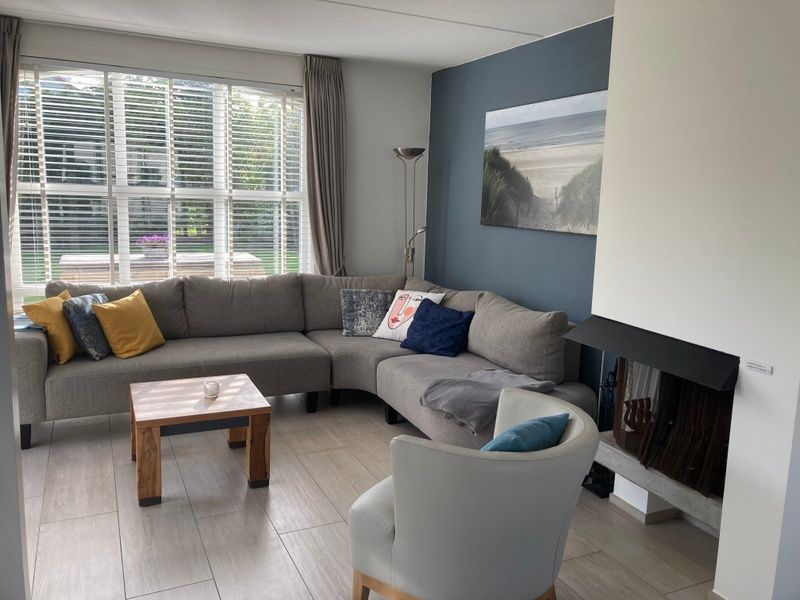 Gezellige woonkamer van Vakantiehuis E 501 in De Cocksdorp, Texel, met comfortabele zithoek en uitzicht op de groene omgeving.
