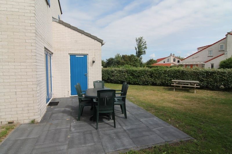 Geniet van het terras van Vakantiehuis E 421 in De Cocksdorp, Texel, omgeven door groene natuur en rust van de Waddeneilanden.