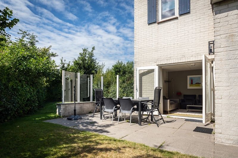 Geniessen Sie den sonnigen Garten und die Terrasse des Ferienhauses E 511 in De Cocksdorp, Texel, ideal fuer einen entspannten Aufenthalt auf den Watteninseln.