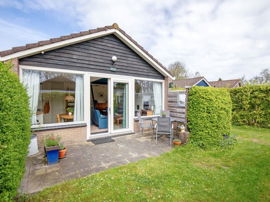 Vakantiehuis Slufterhoek 110 in De Cocksdorp, Texel biedt een uitnodigend terras en groene tuin voor een ontspannen verblijf op de Waddeneilanden.