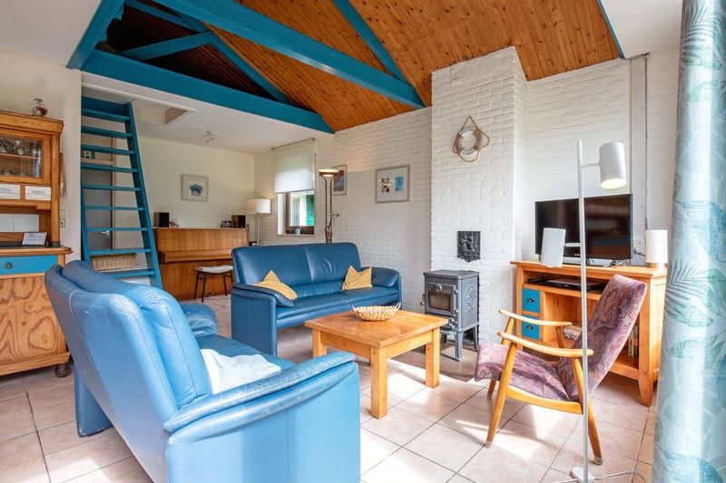 Gezellige woonkamer van Vakantiehuis Slufterhoek 110 in De Cocksdorp, Texel, met comfortabele zitruimte en sfeervolle inrichting.
