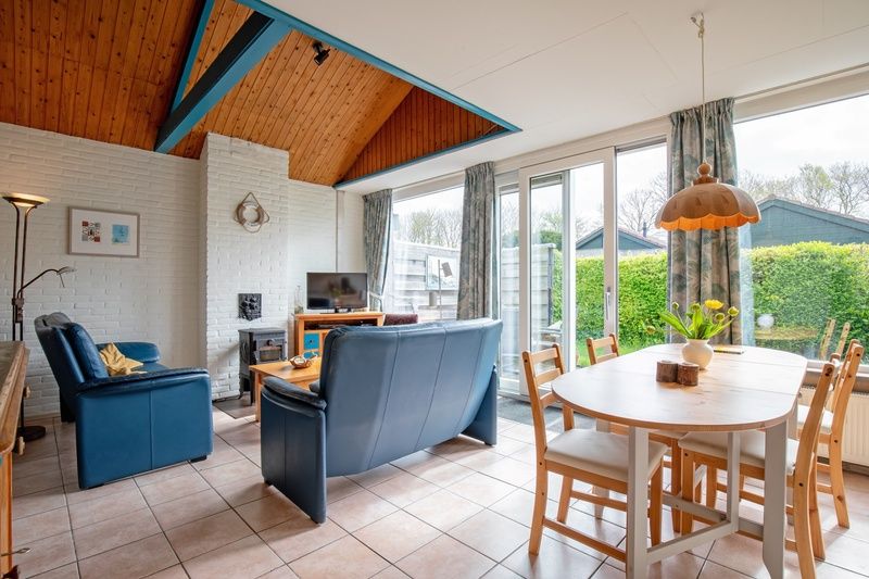 Gezellige woonkamer in Vakantiehuis Slufterhoek 110, De Cocksdorp, Texel. Licht interieur met comfortabele zithoek en uitzicht op de tuin.