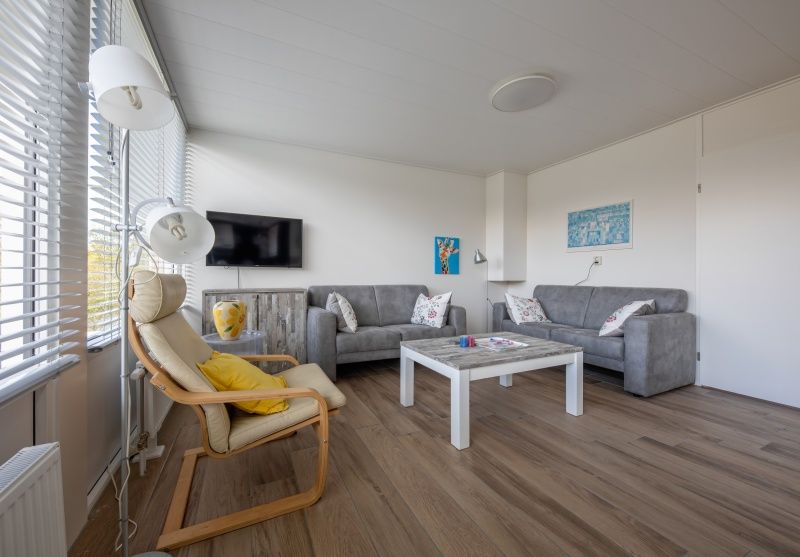 Gezellige woonkamer in Vakantiehuis Slufterhoek 080, De Cocksdorp, Texel, met comfortabele zithoek en moderne inrichting.