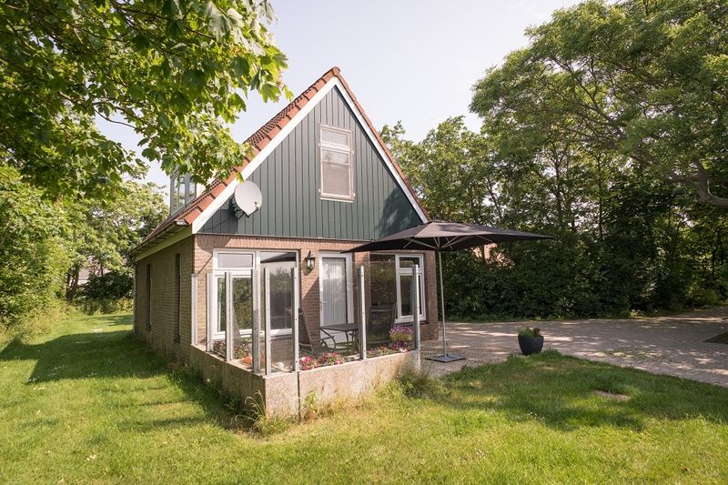 Gezellig vakantiehuis Bungalow Klein Axel in De Cocksdorp, Texel, met zonnig terras en groene omgeving.