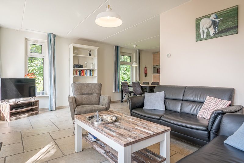 Stijlvolle woonkamer van Bungalow Klein Axel in De Cocksdorp, Texel, met comfortabele zithoek en veel lichtinval.