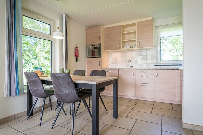 Eetkamer met uitzicht in Bungalow Klein Axel, De Cocksdorp, Texel, ideaal voor gezellige maaltijden tijdens vakantie.
