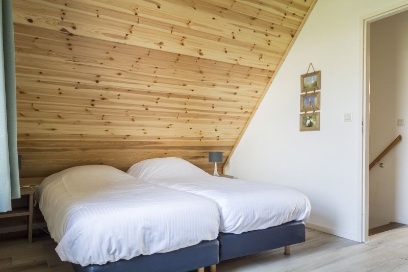 Comfortabele slaapkamer in Bungalow Klein Axel, De Cocksdorp, Texel, met twee eenpersoonsbedden en rustieke sfeer.